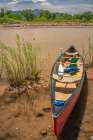 USA, New Mexico, Rio Grande River. Empty canoe on riverbank. Art Print